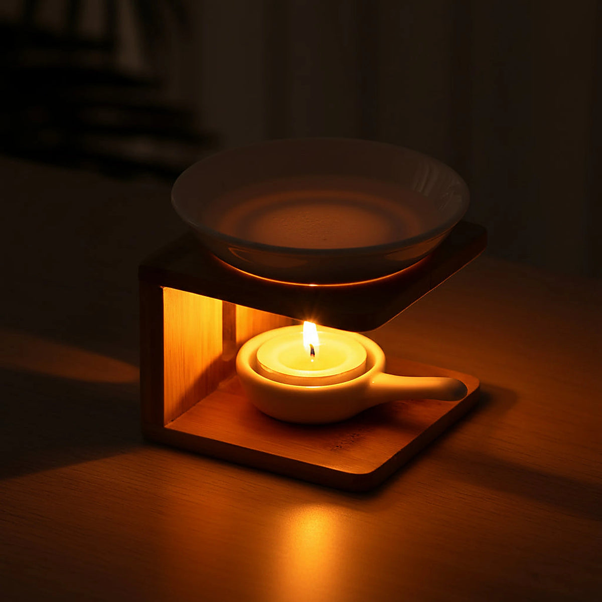 Wooden oil warmer with a lit tealight