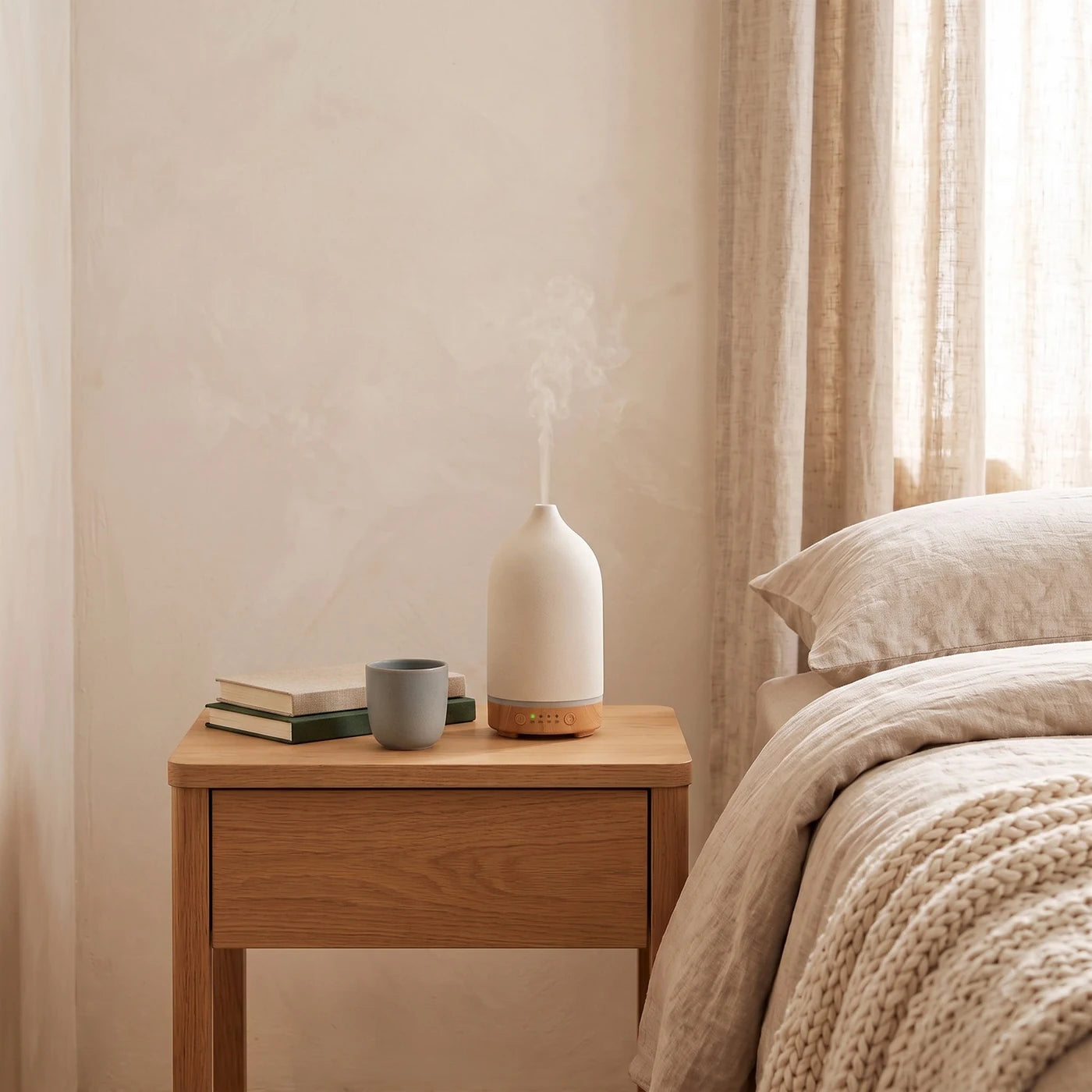 Cream wood-grain diffuser on a nightstand beside a low lamp